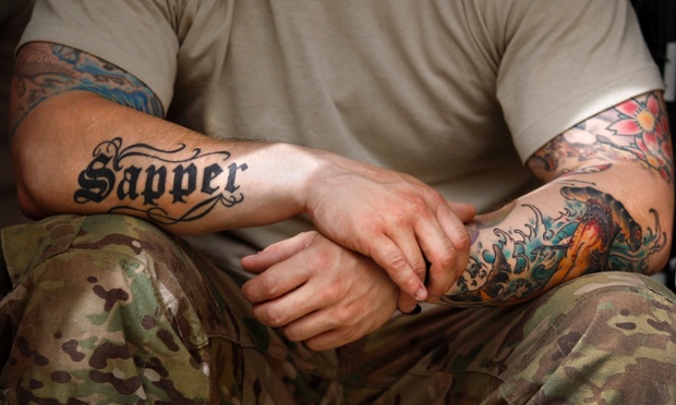 A soldier from the U.S. Army's 1st Platoon, 18th Engineer Company, Task Force Arrowhead rests at Forward Operating Base Mizan in Afghanistan's Zabul Province. The Army is set to introduce a new policy banning tattoos for recruits that show below the elbow and knee and above the neckline