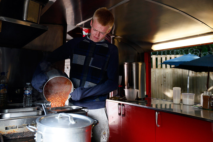 Roadside snacks: Jay Grey prepares baked beans in his roadside double-decker cafe, the Red B