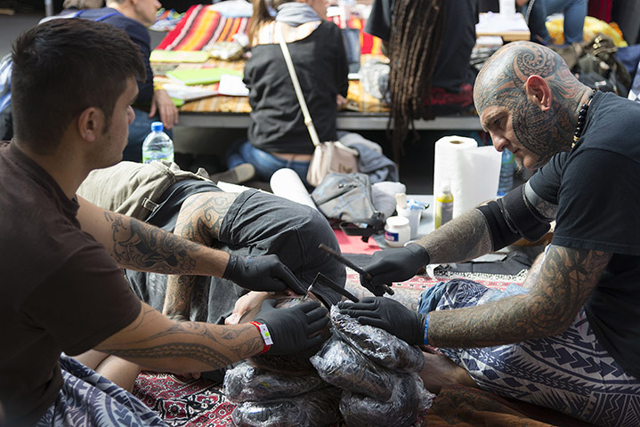 tatts out: A man getting his head tattooed