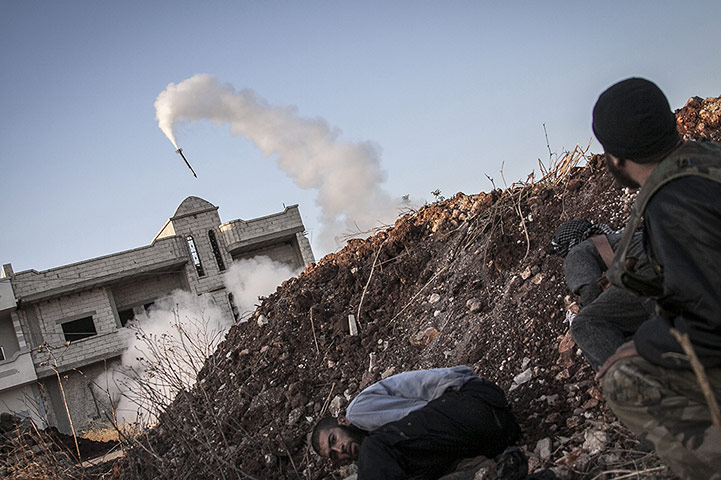 20 Photos: Free Syrian Army fighters take cover after firing a rocket in Idlib