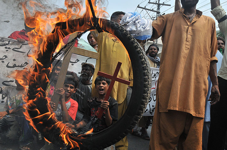 20 Photos: Pakistani Christians hold a burning tyre in Lahore