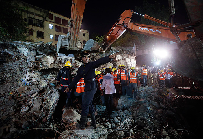 Weekend in pictures: Mumbai, India: A rescue worker calls for a stretcher as others search for s