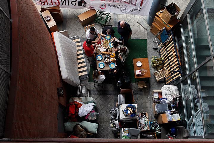 Weekend in pictures: Madrid, Spain: The family of Benigno Ferrer sit on the pavement outside the