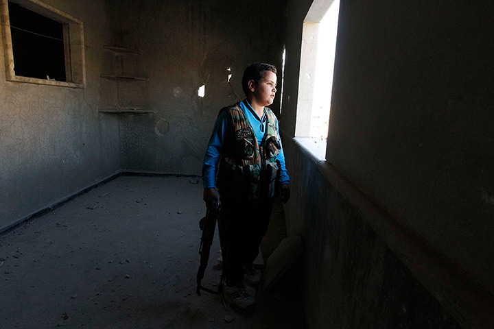 Weekend in pictures: Aleppo, Syria: Abboud, 12, looks out of a damaged building in the Sheikh Sa