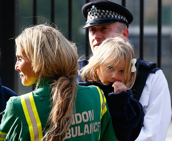 Duck boat on fire: A member of the London Ambulance Service holds a child rescued from the Tha