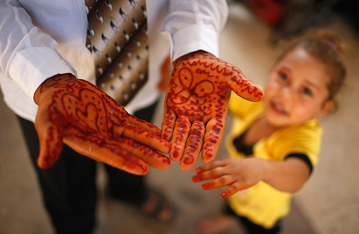Young newlyweds: Traditional henna designs on the groom's hands. Ahmed works with his father