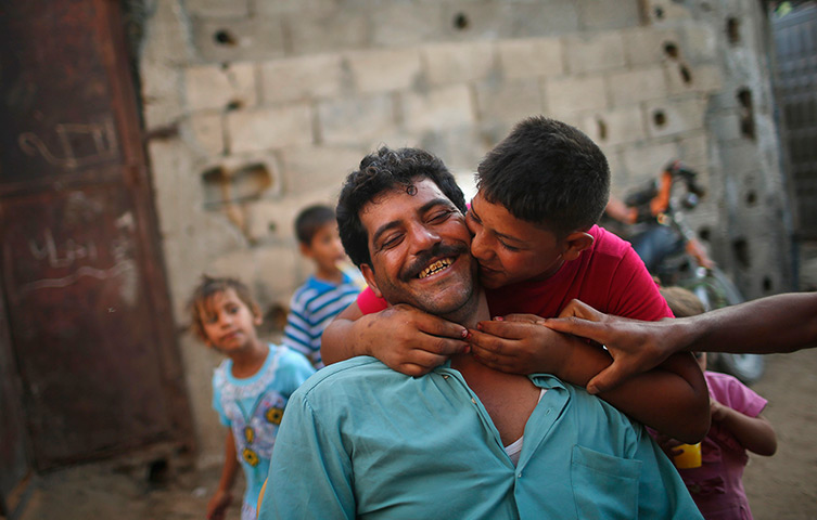 Young newlyweds: Ahmed kisses his bride-to-be's father a day before his wedding 