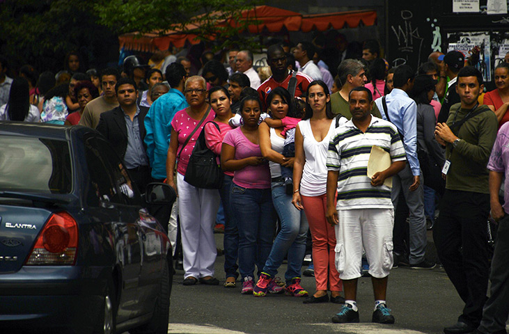 Venezuela blackout: People wait for public transport in a street in the capital Caracas