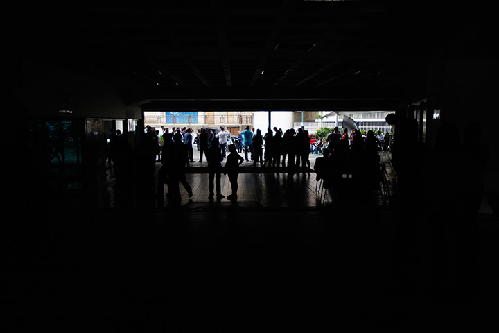Venezuela blackout: People stand outside a shopping mall during a massive blackout in Caracas
