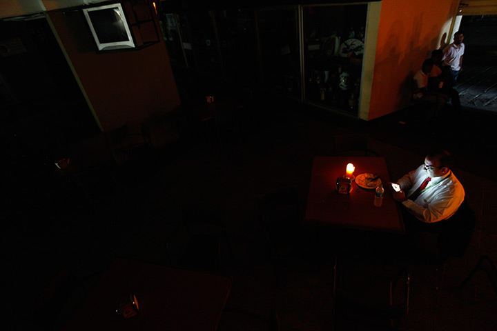 Venezuela blackout: A man sits down to have lunch by candlelight