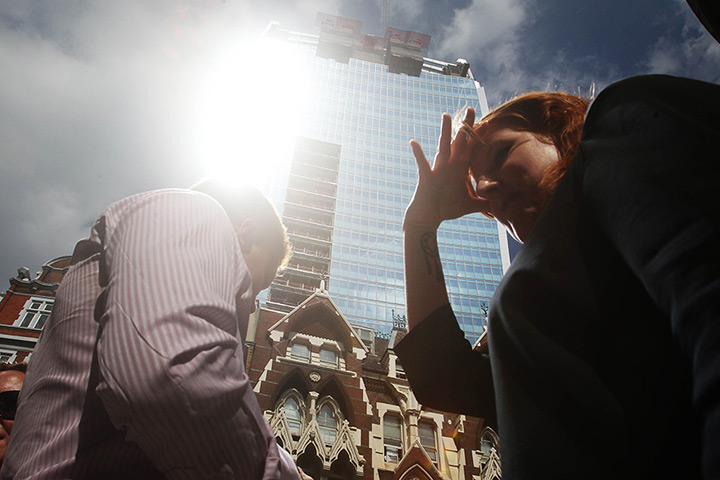 Walkie scorchie: A woman shields her eyes as sunlight is reflected off the building