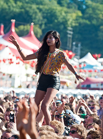 Bestival 2013: A girl stands on the shoulders of a fellow festival-goer 