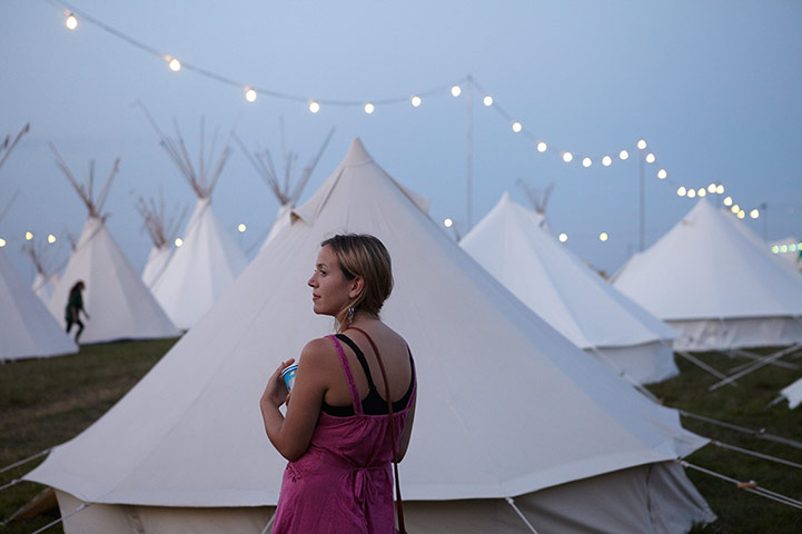 Bestival 2013: A girl stands in the tipi field as the sun sets on day two of the festival