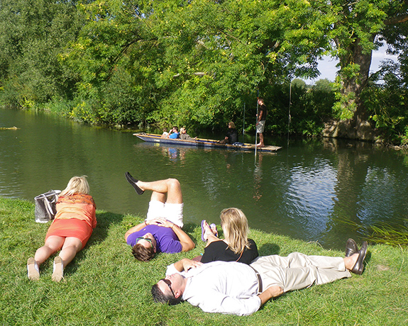 Your Pictures - Chill : four people lying on river bank with boat in background