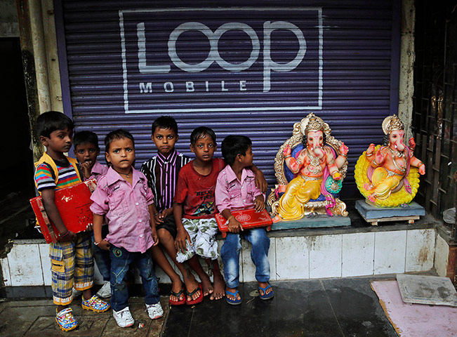 Hindu God Ganesha : Young Indian boys sit next to finished clay idols