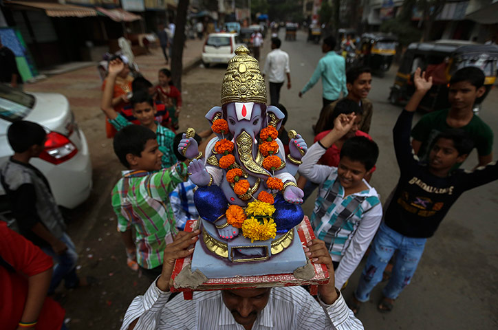 Hindu God Ganesha : A statue decorated with colourful flowers