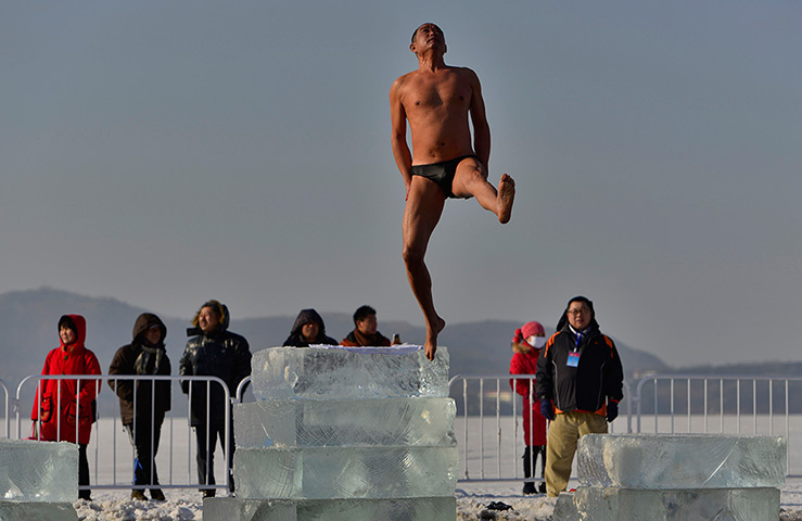 Photo highlights: A participant jumps from an ice brick during a winter triathlon in Shenyang