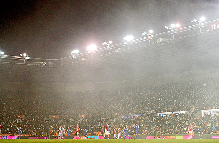 Premier New Years Day : Smoke from a flare envelopes the pitch