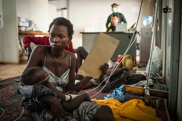20 Photos: A woman holds her child at a makeshift clinic in a camp in Juba