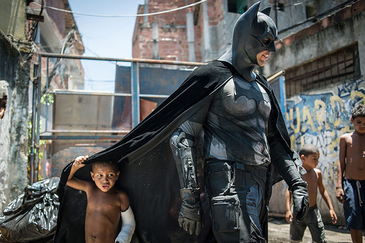 20 Photos: Children play with a man disguised as Batman in Rio de Janeiro, Brazil