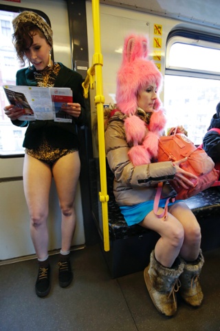 Passengers without their pants use a subway train during the 