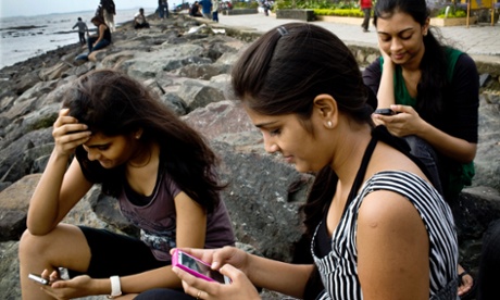 India college students check Facebook accounts on smartphones in Mumbai, India. The country will gain more than 200m new smartphone users in 2014, taking total use there to over 360m according to a new forecast.