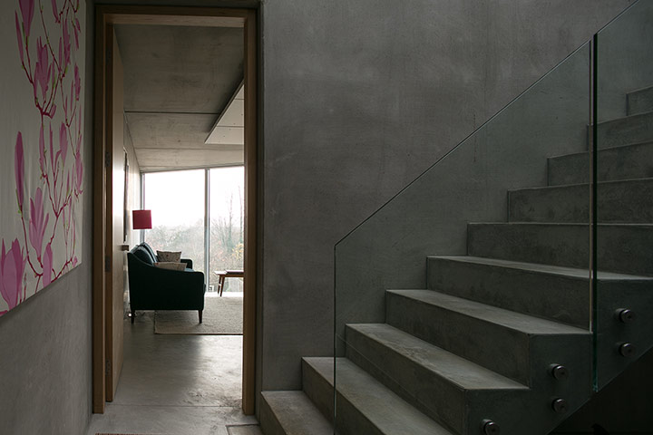 Homes - Concrete house: concrete stairs in hallway looking into room