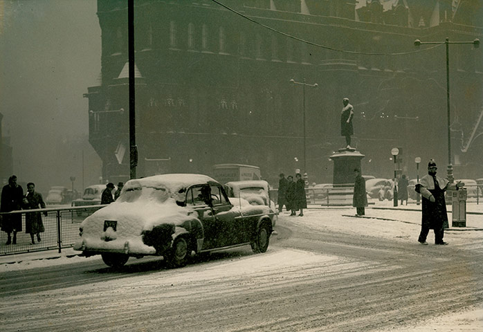 Looking-Back-Policeman: Policeman directs car in snow