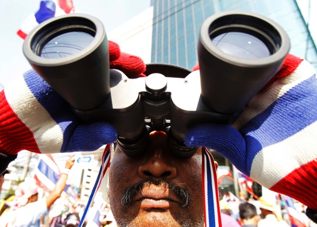 The anti-government protests continue in central Bangkok. A man uses a pair of binoculars to keep an eye on the police.