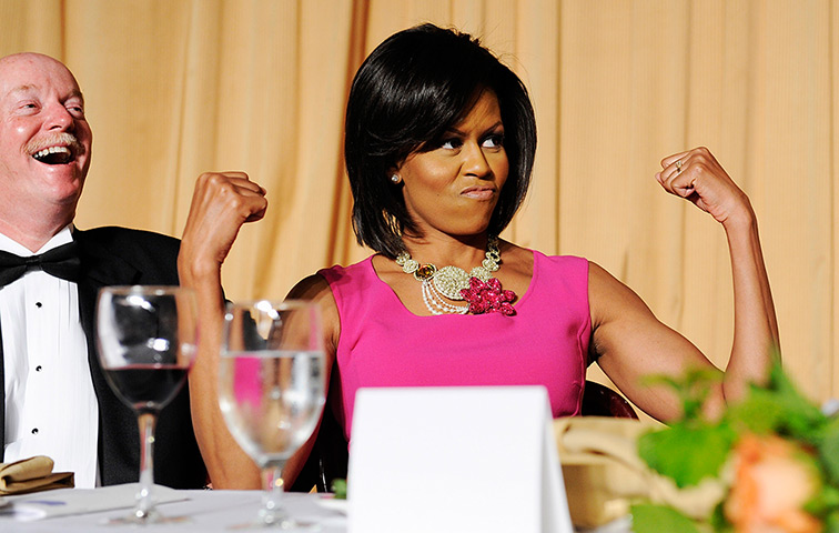 Michelle Obama at 50: May 9, 2009: First lady Michelle Obama flexes her arms in response to a jok