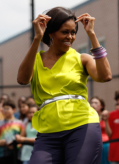 Michelle Obama at 50: May 3, 2011: First lady Michelle Obama dances during a surprise visit to Al