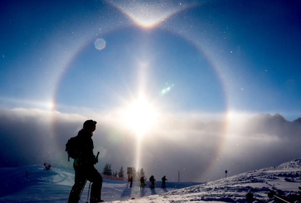 The sun creates a halo over skiers at Fellhorn in Oberstdorf, Germany. Also called a nimbus or icebow, a sun halo is a natural phenomenon created by refractions from ice crystals suspended in the air.