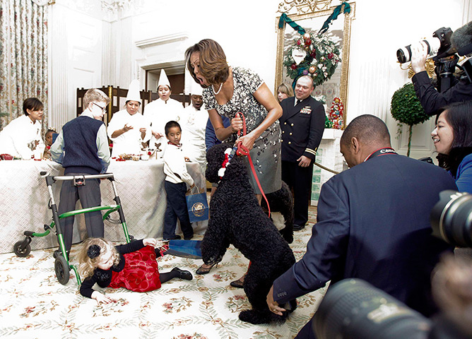 Michelle Obama at 50: December 4, 2013: Frst lady Michelle Obama reacts as a toddler trips over a