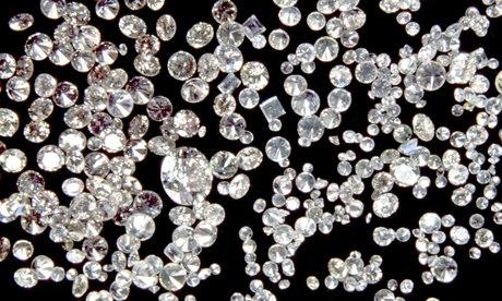 Assorted cut and polished diamonds on a black velvet cloth.