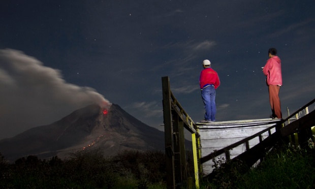 Villagers from nearby Jraya village, in North Sumatra, Indonesia, watch Mount Sinabung spewing lava and ash into the night sky.