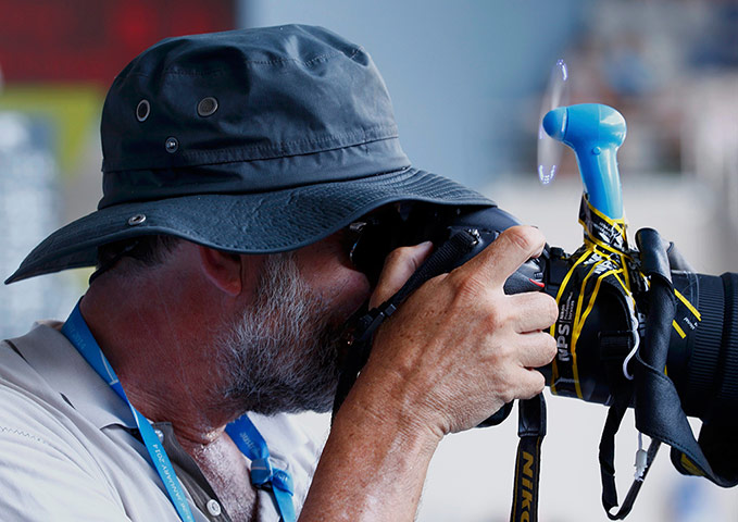 aussie open day 5: A photographer keeps cool with a fan taped to his camera