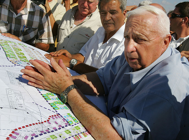 Ariel Sharon in pictures: 2005: Israeli Prime Minister Ariel Sharon leans over housing plans as he me