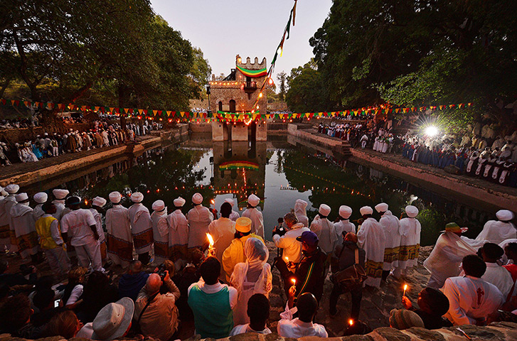 FTA: Carl de Souza: Pilgrims pray by candlelight during a ceremony at the Fasilides baths as pa