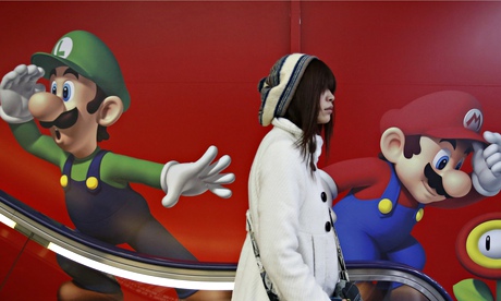 A shopper rides an escalator past Nintendo ads at an electronics retail store in Tokyo