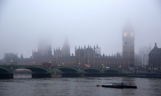 The Houses of Parliament and the river Thames are shrouded in early morning fog in London, UK.
