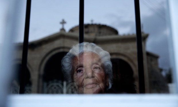 The reflection of Chrysaliniotissa Church is seen in a window pane as a woman looks out in the old city of the Cypriot capital Nicosia.