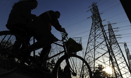 A couple sharing a bicycle ride past ele