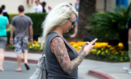 Woman looking at phone as he crosses road