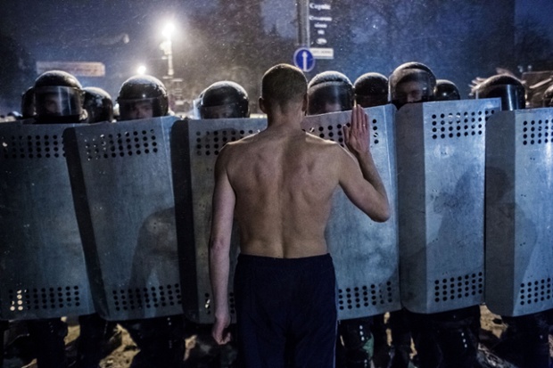 A protester stands in front of a line of police. Ukrainian opposition leaders emerged from crisis talks with President Viktor Yanukovich saying he had failed to give concrete answers to their demands, and told their supporters on the streets to prepare for a police offensive