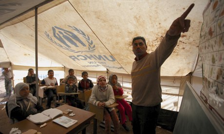 Syrian refugee children learn inside a makeshift tent class