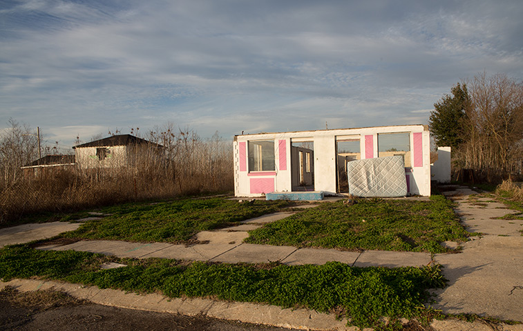 Rebuilding New Orleans: A discarded mattress left in front of the shell of a building