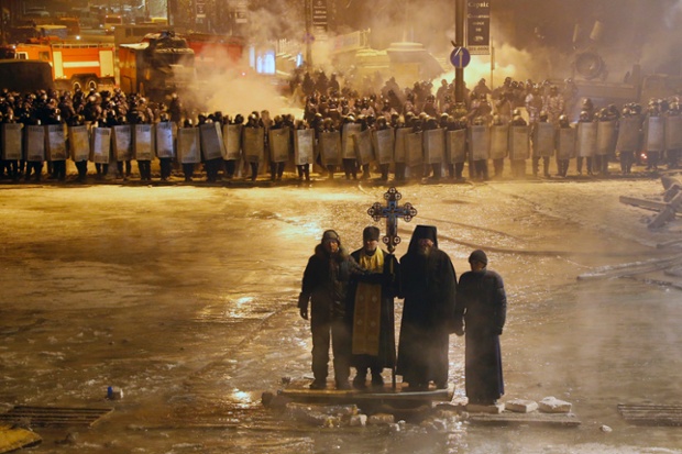 Orthodox priests pray as they stand between pro-European Union activists and police lines in central Kiev, Ukraine. A top Ukrainian opposition leader on Thursday urged protesters to maintain a shaky cease-fire with police after at least two demonstrators were killed in clashes this week.