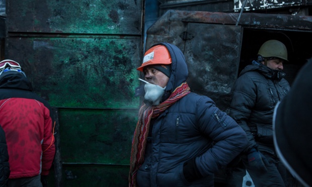 Anti-government protesters guard a burnt barricade on a street near Dynamo stadium in Kiev, Ukraine.