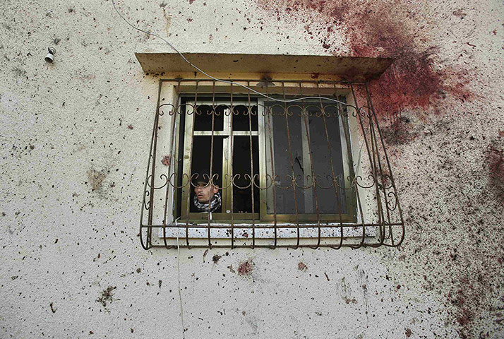 20 Photos: A Palestinian man looks out a window beside bloodstains in Beit Hanoun
