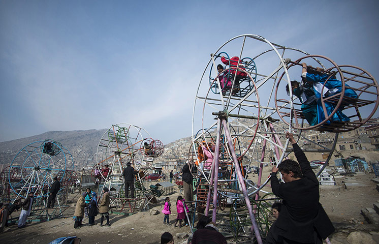 20 Photos: Afghan children ride on ferris wheels near a cemetery in Kabul